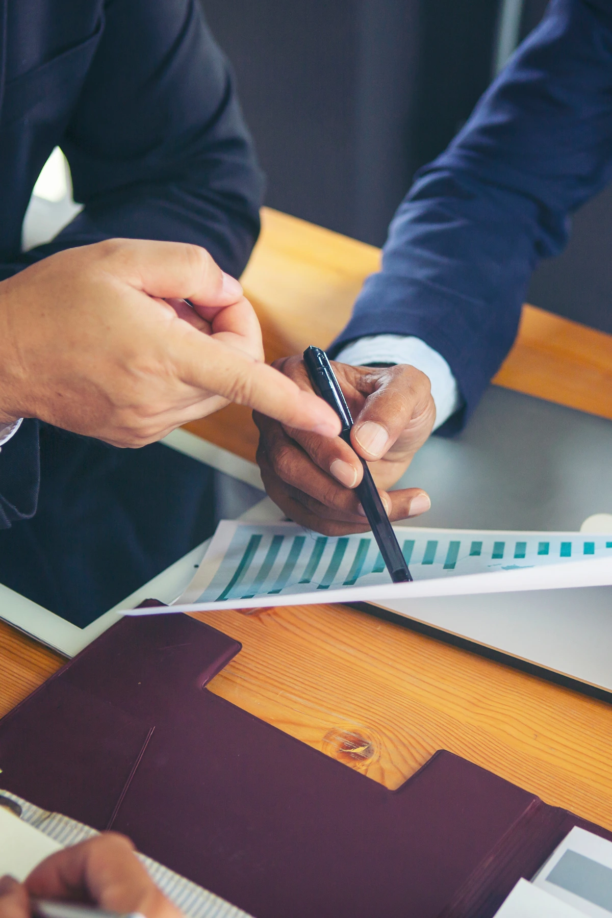 Professionals reviewing documents during deal negotiation
